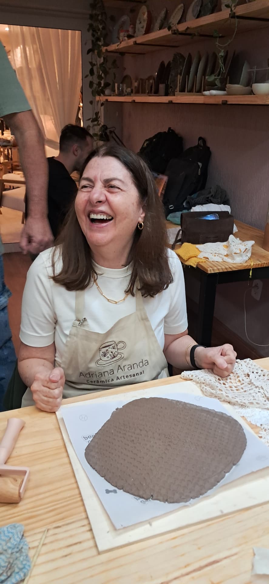 Aluna sorrindo durante a aula de cerâmica